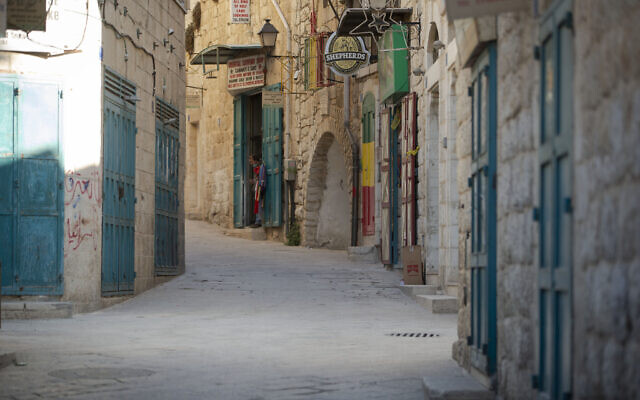 A Palestinian vendor stands in front of his shop near the Church of the Nativity, traditionally believed to be the birthplace of Jesus Christ, in the West Bank City of Bethlehem, on Monday, November 23, 2020. (AP Photo/Majdi Mohammed)