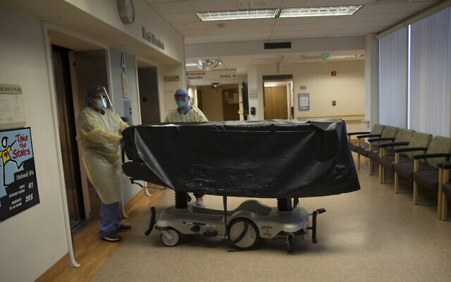 Hospital staff members enter an elevator with the body of a COVID-19 victim on a gurney at St. Jude Medical Center in Fullerton, California, July 7, 2020. (AP Photo/Jae C. Hong, File) Hospital staff members enter an elevator with the body of a COVID-19 victim on a gurney at St. Jude Medical Center in Fullerton, California, July 7, 2020. (AP Photo/Jae C. Hong, File)