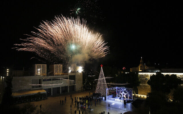 Palestinian Christians attend the lighting of a Christmas tree outside the Church of the Nativity, traditionally believed by Christians to be the birthplace of Jesus Christ in the West Bank city of Bethlehem, Saturday, Dec. 5, 2020. (AP Photo/Majdi Mohammed)