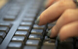 In this October 8, 2019 file photo, a woman types on a keyboard in New York. (AP Photo/Jenny Kane, File)
