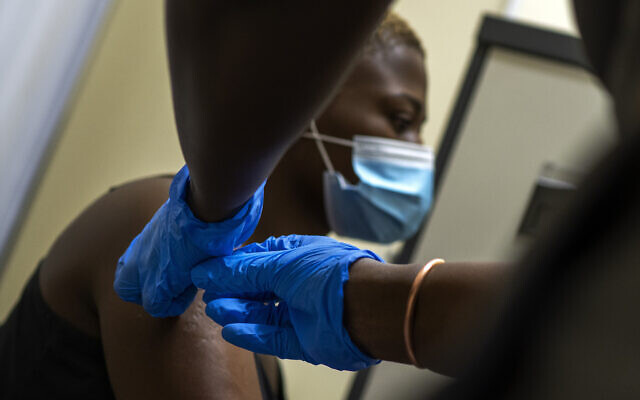 Thabisle Khlatshwayo, receives her second shot at a vaccine trial facility for AstraZeneca at Soweto's Chris Sani Baragwanath Hospital outside Johannesburg, South Africa, Monday Nov. 30, 2020. With Americans, Britons and Canadians now rolling up their sleeves to receive coronavirus vaccines, the route out of the pandemic now seems clear to many in the West, even if the rollout will take many months. But for poorer countries, the road will be far longer and rougher. (AP Photo/Jerome Delay) Thabisle Khlatshwayo, receives her second shot at a vaccine trial facility for AstraZeneca at Soweto's Chris Sani Baragwanath Hospital outside Johannesburg, South Africa, Monday Nov. 30, 2020. With Americans, Britons and Canadians now rolling up their sleeves to receive coronavirus vaccines, the route out of the pandemic now seems clear to many in the West, even if the rollout will take many months. But for poorer countries, the road will be far longer and rougher. (AP Photo/Jerome Delay)
