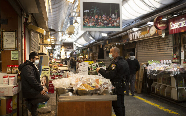 A policeman advises a vendor at the Mahane Yehuda market in Jerusalem, Dec. 28, 2020, during Israel's third nationwide lockdown to curb the spread of the coronavirus. (AP Photo/Maya Alleruzzo) A policeman advises a vendor at the Mahane Yehuda market in Jerusalem, Dec. 28, 2020, during Israel's third nationwide lockdown to curb the spread of the coronavirus. (AP Photo/Maya Alleruzzo)