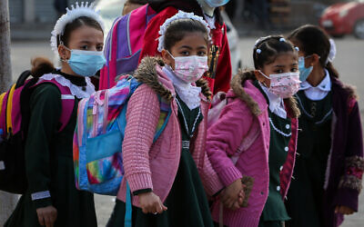 Palestinian students affiliated with the United Nations "UNRWA" wear face masks amid the coronavirus pandemic, in Rafah, in the south of the Gaza Strip, on November 25, 2020. (Abed Rahim Khatib/Flash90)