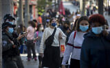 People wearing a face mask walk in the Jerusalem city center on November 29, 2020, as Israel steps out of its coronavirus lockdown and rolls back restrictions. (Olivier Fitoussi/Flash90)