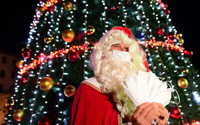A man dressed as Santa Claus seen during the annual Christmas tree lighting ceremony in Jaffa, December 6, 2020 (Tomer Neuberg/Flash90)