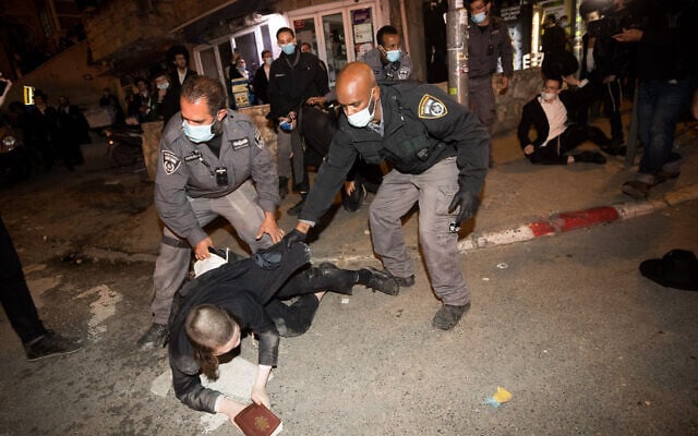 Ultra-Orthodox men scuffle with police as they protest against work for the Jerusalem Light Rail, December 7, 2020. (Yonatan Sindel/Flash90)