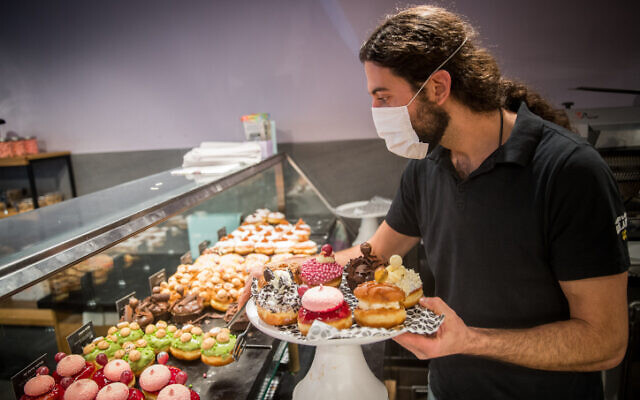 Sufganiyot donuts sold at a bakery ahead of Hanukkah, outside the Mahane Yehuda Market in Jerusalem, on December 7, 2020 (Yonatan Sindel/Flash90) Sufganiyot donuts sold at a bakery ahead of Hanukkah, outside the Mahane Yehuda Market in Jerusalem, on December 7, 2020 (Yonatan Sindel/Flash90)