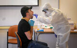 Health care workers take coronavirus test samples at a testing center, in Rishon Lezion on December 8, 2020. (Flash90)