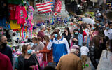 People wear protective masks at the Carmel market in Tel Aviv, on December 13, 2020. (Miriam Alster/FLASH90)