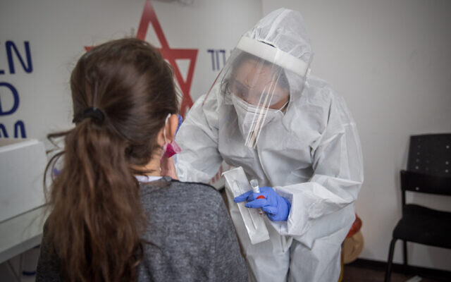 A Magen David Adom medical worker test Israelis for coronavirus at a mobile testing site in Jerusalem on December 16, 2020. (Yonatan Sindel/Flash90) A Magen David Adom medical worker test Israelis for coronavirus at a mobile testing site in Jerusalem on December 16, 2020. (Yonatan Sindel/Flash90)