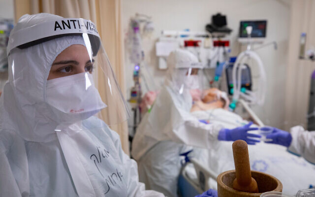 Staff at Shaare Zedek Medical Center in Jerusalem wearing protective  gear as they work at the coronavirus ward, on December 17, 2020 (Olivier Fitoussi/Flash90)