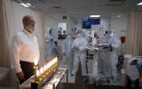 Staff at Shaare Zedek Medical Center and patients light Hanukkah candles at the hospital's coronavirus ward in Jerusalem on December 17, 2020 (Olivier Fitoussi/Flash90)