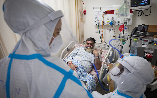 A COVID-19 patient hospitalized at the Shaare Zedek hospital Coronavirus ward receives a visit from his two daughters in Jerusalem on December 17, 2020. (Olivier Fitoussi/Flash90) A COVID-19 patient hospitalized at the Shaare Zedek hospital Coronavirus ward receives a visit from his two daughters in Jerusalem on December 17, 2020. (Olivier Fitoussi/Flash90)