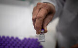 A nurse holds vaccines against the coronavirus as they arrive at Shaarei Tzedek hospital in Jerusalem, prior to the start of the vaccination of the Israeli population, on December 19, 2020. (Yonatan Sindel/Flash90)