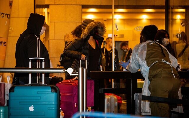 Passengers who arrived on a flight from England arrive at the Dan Panorama Hotel in Jerusalem, used as a quarantine facility, on December 20, 2020. (Yonatan Sindel/Flash90) Passengers who arrived on a flight from England arrive at the Dan Panorama Hotel in Jerusalem, used as a quarantine facility, on December 20, 2020. (Yonatan Sindel/Flash90)