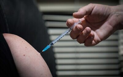 A medical staff member receives a COVID-19 vaccine, at the Hadassah Medical Center, on December 20, 2020 in Jerusalem. (Yonatan Sindel/Flash90)