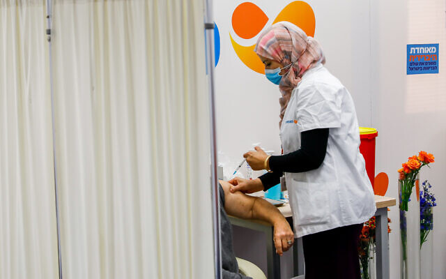 An Israeli citizen receives a COVID-19 vaccine, at a Meuhedet vaccination center in Jerusalem, on December 21, 2020. (Olivier Fitoussi/Flash90) An Israeli citizen receives a COVID-19 vaccine, at a Meuhedet vaccination center in Jerusalem, on December 21, 2020. (Olivier Fitoussi/Flash90)