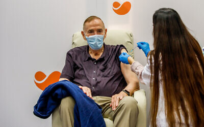 An Israeli citizen receives a COVID-19 vaccine, at a Meuhedet vaccination center in Jerusalem, on December 21, 2020. (Olivier Fitoussi/Flash90)