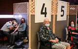 Israelis receive Covid-19 vaccinations, at the Mediterranean Towers assisted-living facility in Ganei Tikva, southeast of Tel Aviv, December 22, 2020. (Flash90)