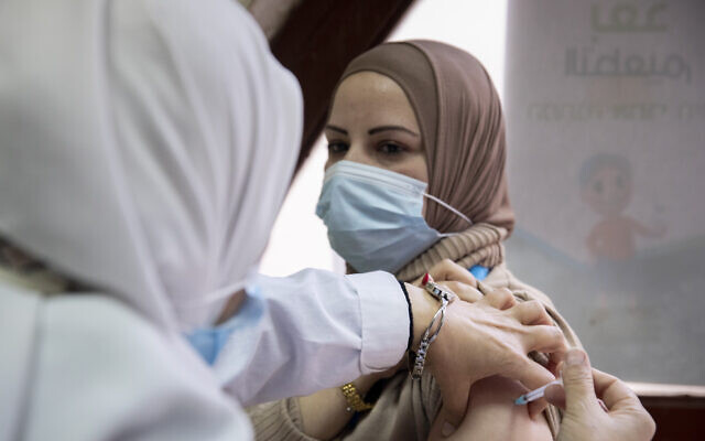 A woman receives a COVID-19 vaccine in Jerusalem, on December 23, 2020 (Olivier Fitoussi/Flash90)