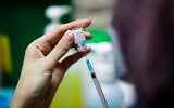 An Israeli nurse prepares a COVID-19 vaccine at a vaccination center in Jerusalem on December 23, 2020. (Olivier Fitoussi/Flash90)