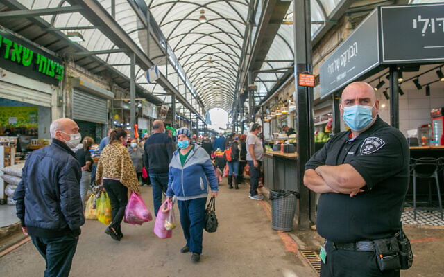 Israelis shop at the market in Ramle. The market has been partially closed down due to restrictions to prevent the spread of the coronavirus. December 23, 2020. (Yossi Aloni/FLASH90) Israelis shop at the market in Ramle. The market has been partially closed down due to restrictions to prevent the spread of the coronavirus. December 23, 2020. (Yossi Aloni/FLASH90)