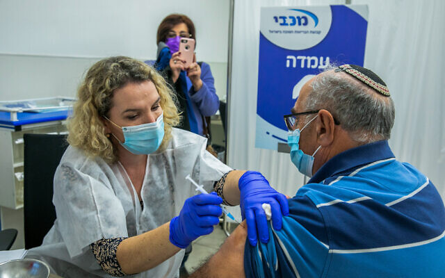 A man receives a COVID-19 vaccine at Maccabi Healthcare Services vaccination center in Modiin, on December 24, 2020. (Yossi Aloni/Flash90) A man receives a COVID-19 vaccine at Maccabi Healthcare Services vaccination center in Modiin, on December 24, 2020. (Yossi Aloni/Flash90)