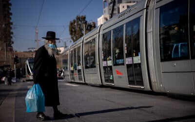 A man wearing a face mask near the Mahane Yehuda market in Jerusalem on December 25, 2020. (Yonatan Sindel/Flash90)