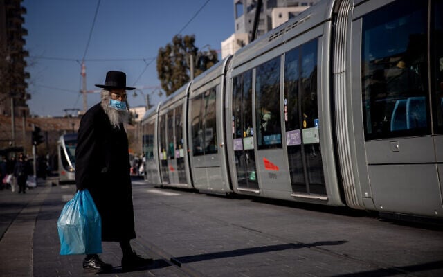 A man wearing a face mask near the Mahane Yehuda market in Jerusalem on December 25, 2020. (Yonatan Sindel/Flash90) A man wearing a face mask near the Mahane Yehuda market in Jerusalem on December 25, 2020. (Yonatan Sindel/Flash90)