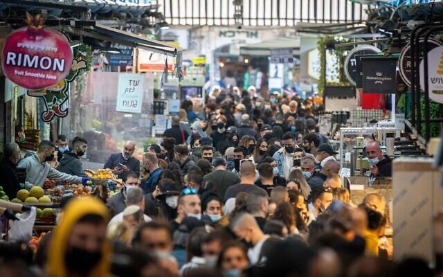 People wearing face masks shop at the Mahane Yehuda Market in Jerusalem on December 25, 2020. (Yonatan Sindel/Flash90) People wearing face masks shop at the Mahane Yehuda Market in Jerusalem on December 25, 2020. (Yonatan Sindel/Flash90)