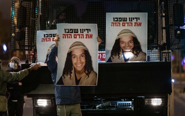 Demonstrators holds placards showing Ahuvia Sandak as they protest against his death in a car crash during a police chase, outside the national police headquarters in Jerusalem, on December 26, 2020. (Yonatan Sindel/ Flash90) Demonstrators holds placards showing Ahuvia Sandak as they protest against his death in a car crash during a police chase, outside the national police headquarters in Jerusalem, on December 26, 2020. (Yonatan Sindel/ Flash90)
