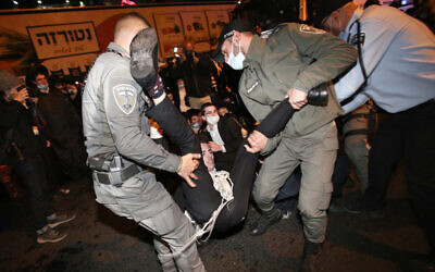 Police clash with ultra-Orthodox Jews protesting the arrest of a draft dodger, in the central city of Bnei Brak, December 27, 2020. (Noam Revkin Fenton/Flash90)