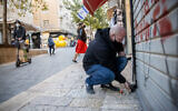 A man closes his shop in Jerusalem on December 27, 2020, as Israel enters its 3rd nationwide lockdown. (Yonatan Sindel/Flash90)
