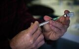 People receives a Covid-19 vaccine, at Clalit Covid-19 vaccination center in Jerusalem, on December 28, 2020. (Yonatan Sindel/Flash90)