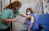 An Israeli teacher receives a COVID-19 vaccine at Shamir Medical Center in Be'er Ya'akov, December 30, 2020. (Avi Dishi/Flash90)