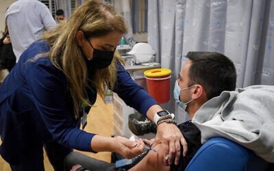 An Israeli teacher receives a COVID-19 vaccine, at the Shamir Medical Center in Be'er Ya'akov, on December 30, 2020. (Avi Dishi/Flash90)