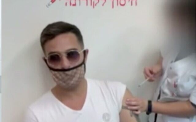 Screen capture from video of Shimon Hayut getting a coronavirus vaccination injection, December 28, 2020. (Channel 12 news) Screen capture from video of Shimon Hayut getting a coronavirus vaccination injection, December 28, 2020. (Channel 12 news)