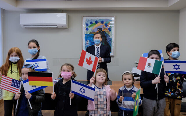 Chairman of The Jewish Agency Isaac Herzog, center, meeting with children who immigrated to Israel during the coronavirus pandemic, December 28, 2020. (David Salem/The Jewish Agency for Israel) Chairman of The Jewish Agency Isaac Herzog, center, meeting with children who immigrated to Israel during the coronavirus pandemic, December 28, 2020. (David Salem/The Jewish Agency for Israel)