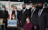 Prime Minister Benjamin Netanyahu (4L) and Health Minister Yuli Edelstein (2L) accompany David Herzl Levy as he becomes the 500,000th Israeli to receive a coronavirus vaccine.(Amos Ben-Gershom/GPO)