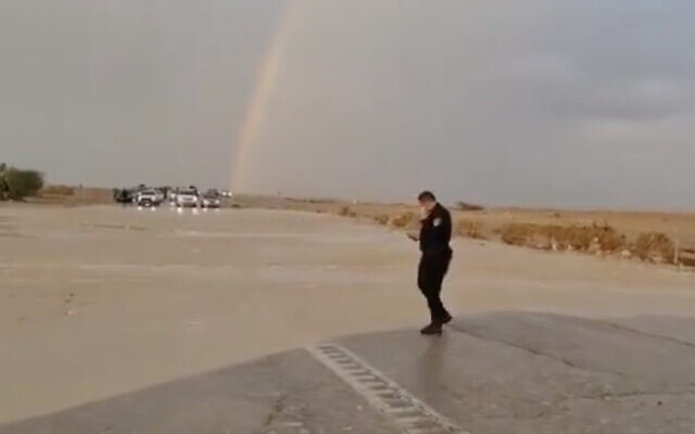 A police officer is seen next to a flooded portion of Route 90 in southern Israel, on December 5, 2020. (Screen capture: Twitter) A police officer is seen next to a flooded portion of Route 90 in southern Israel, on December 5, 2020. (Screen capture: Twitter)