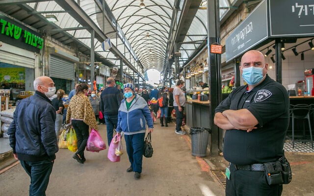 Israelis shop at the market in Ramle, central Israel, that is partially closed due to coronavirus restrictions, December 23, 2020. (Yossi Aloni/Flash90) Israelis shop at the market in Ramle, central Israel, that is partially closed due to coronavirus restrictions, December 23, 2020. (Yossi Aloni/Flash90)