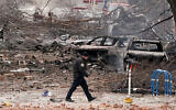 A law enforcement member walks past damage from an explosion in downtown Nashville, Tennessee, December 25, 2020. (AP/Mark Humphrey)