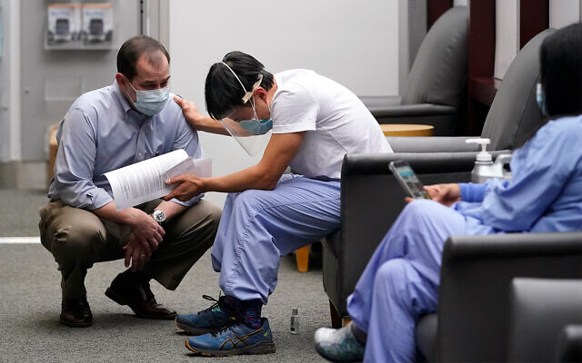Dr. Thuan Ong, center, speaks about his coronavirus patients before receiving a COVID-19 vaccination in Seattle, Washington, December 15, 2020. (AP Photo/Elaine Thompson) Dr. Thuan Ong, center, speaks about his coronavirus patients before receiving a COVID-19 vaccination in Seattle, Washington, December 15, 2020. (AP Photo/Elaine Thompson)