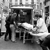 Nurses and rescue workers carry an injured person into the back of an ambulance after the terror attack on Aug. 9, 1982, on Jewish restaurant and deli, Jo Goldenberg, in Paris, France. (AP Photo/ Aulnay)