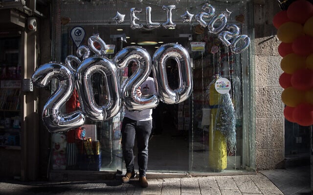 Celebratory 2020 balloons are hung from a storefront in Jerusalem on New Year's Eve, December 31, 2019. (Hadas Parush/Flash90) Celebratory 2020 balloons are hung from a storefront in Jerusalem on New Year's Eve, December 31, 2019. (Hadas Parush/Flash90)