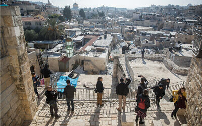 Visitors tour the Jerusalem Ramparts Walk on Jerusalem's Old City walls, on December 17, 2019. (Yonatan Sindel/Flash90)