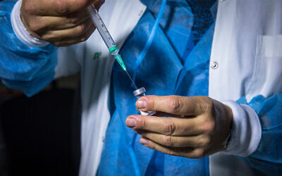 A nurse prepares a vial of coronavirus vaccine in Jerusalem, December 29, 2020. (Olivier Fitoussi/Flash90)