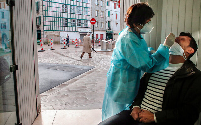 A pharmacist administers a nasal swab at a pharmacy in Bayonne, southwestern France, Dec.24, 2020. (AP/Bob Edme) A pharmacist administers a nasal swab at a pharmacy in Bayonne, southwestern France, Dec.24, 2020. (AP/Bob Edme)
