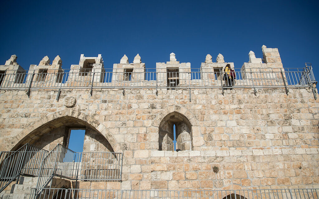 A visitor tours the Jerusalem Ramparts Walk on Jerusalem's Old City walls, on December 17, 2019. (Yonatan Sindel/Flash90)