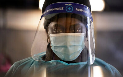 A coronavirus tester speaks to a patient at a mobile testing location in Auburn, Maine, Dec. 8, 2020. (AP Photo/Robert F. Bukaty)